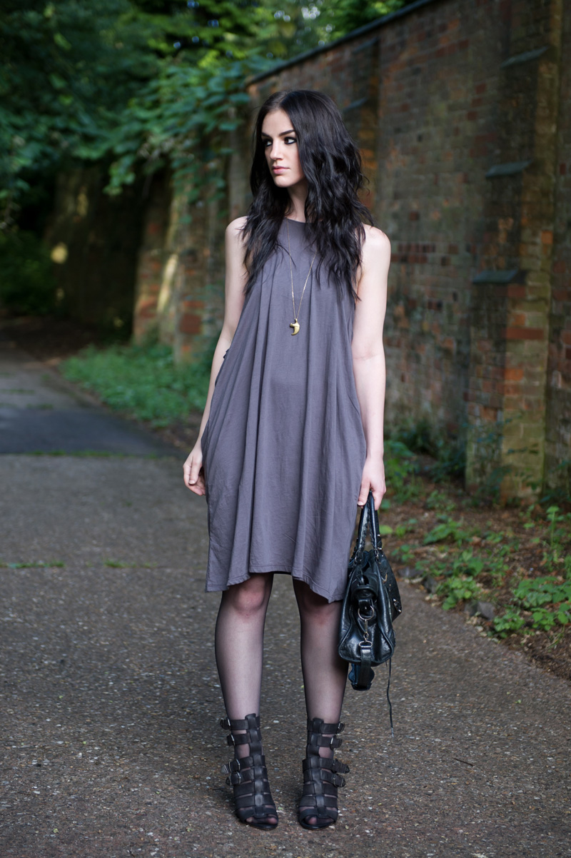 Fashion blogger Stephanie of FAIIINT wearing Cheap Monday taupe draped dress from Surfdome, Braza bandeau bra, Topshop black gladiator buckled wedges, Lion claw pendant, Balenciaga city bag. Casual dark style, street style.