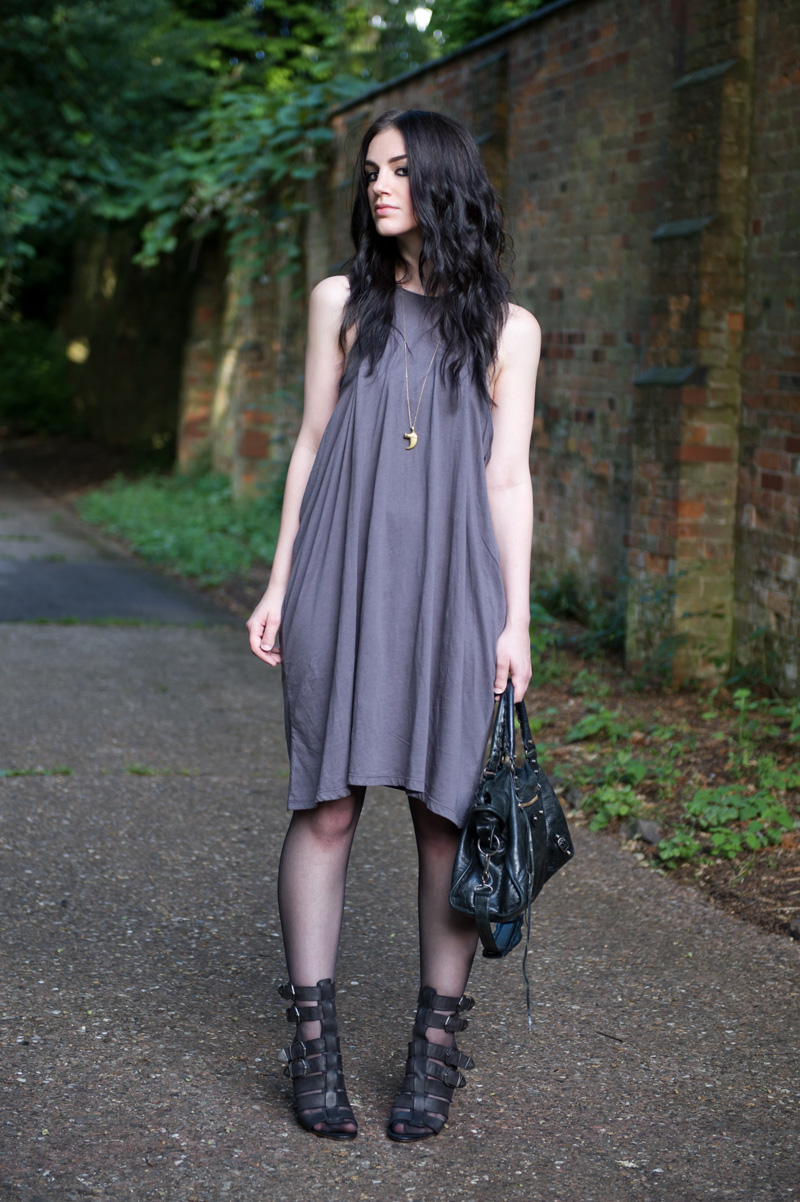 Fashion blogger Stephanie of FAIIINT wearing Cheap Monday taupe draped dress from Surfdome, Braza bandeau bra, Topshop black gladiator buckled wedges, Lion claw pendant, Balenciaga city bag. Casual dark style, street style.