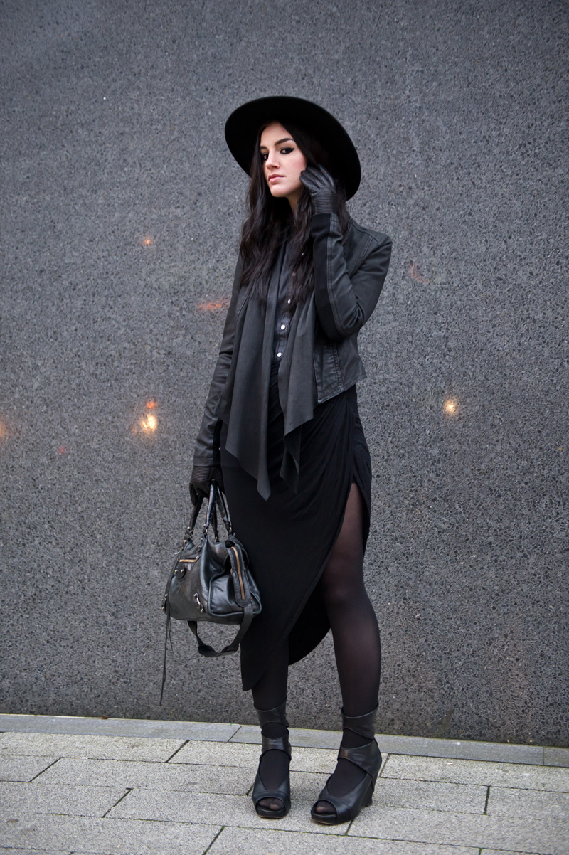 fashion blogger Stephanie of FAIIINT wearing Catarzi fedora, Barneys Originals draped leather jacket, Chiara fashion denim shirt, River Island asymmetric skirt, Rick Owens wedges, Balenciaga city. Dark fashion, all black outfit, tailored, androgynous.