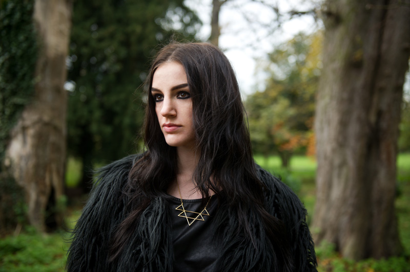 Fashion blogger Stephanie of FAIIINT wearing Lookbook Store faux fur black longhaired coat, H&M leather look tee, RockLove sacred geometry geo necklace, River Island asymmetric skirt, Rick Owens wedges, Balenciaga city bag. All black outfit, Game of Thrones crow coat