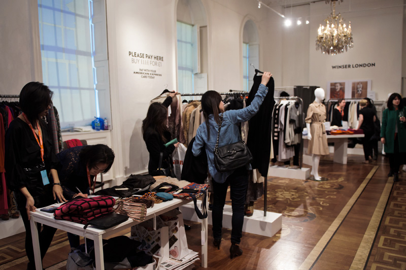 London fashion weekend designer shopping, Somerset House. Shoppers looking at clothes.