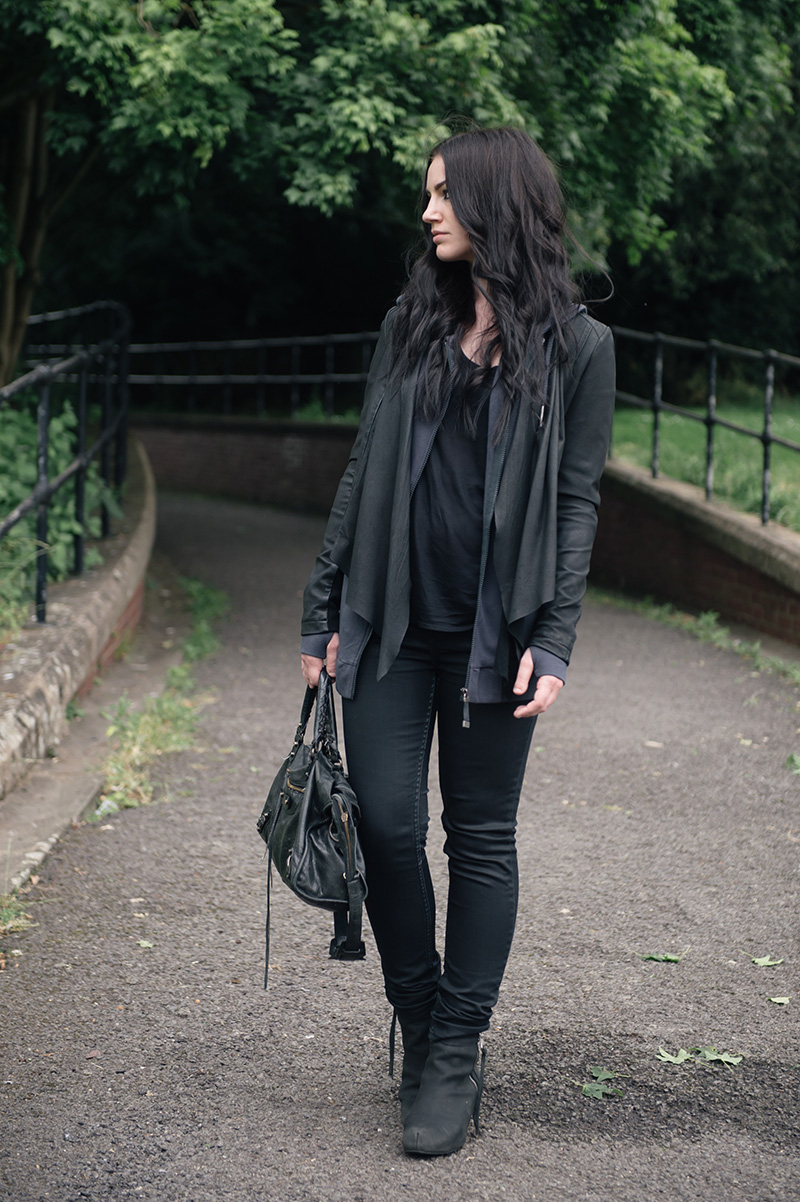 Fashion blogger Stephanie of FAIIINT wearing Barneys originals draped leather jacket, OnePiece charcoal stroll hoodie, Helmut Lang tee, Topshop coated jeans, Kurt Geiger wedges & Balenciaga city bag. All black off duty casual street style outfit.