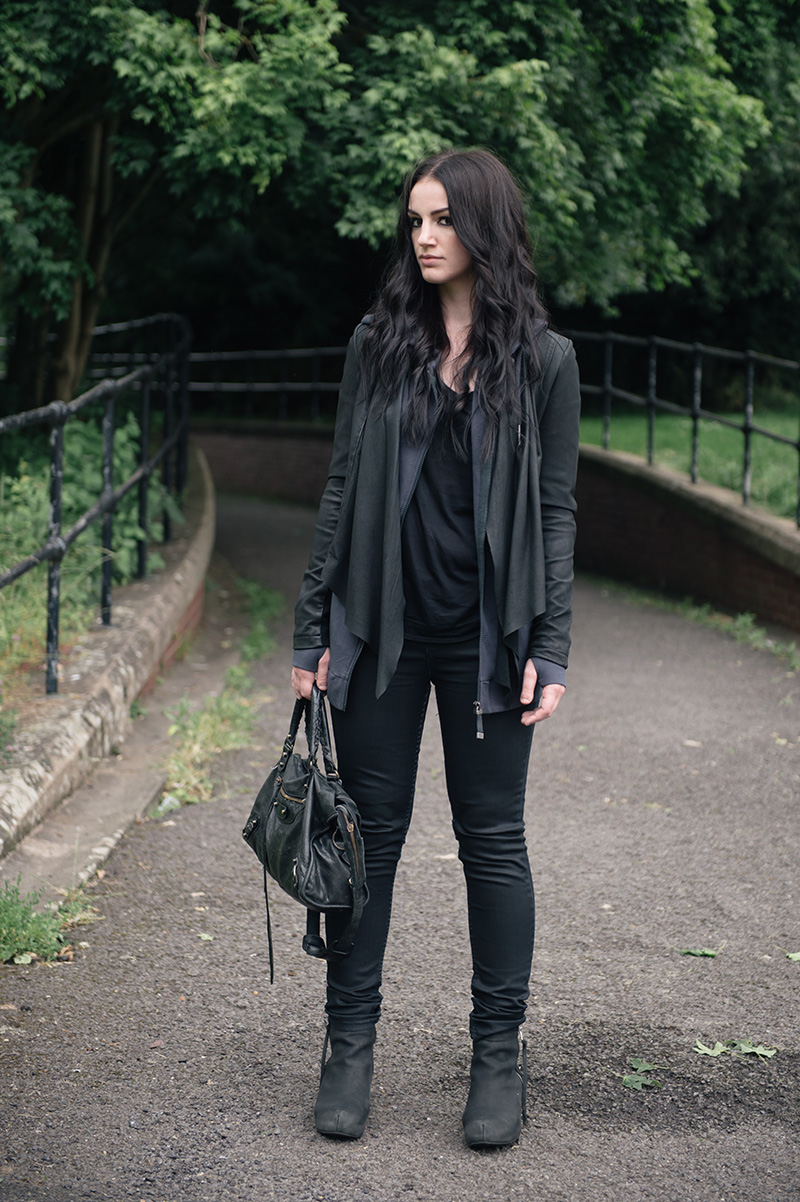 Fashion blogger Stephanie of FAIIINT wearing Barneys originals draped leather jacket, OnePiece charcoal stroll hoodie, Helmut Lang tee, Topshop coated jeans, Kurt Geiger wedges & Balenciaga city bag. All black off duty casual street style outfit.