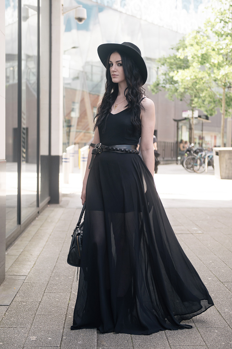 Fashion blogger Stephanie of FAIIINT wearing Choies black chiffon maxi dress, Catarzi Fedora, ASOS & Topshop studded wrap belt, RockLove sacred geometry gold chevron necklace, Kurt Geiger boots, Balenciaga city. All black summer goth street style outfit.