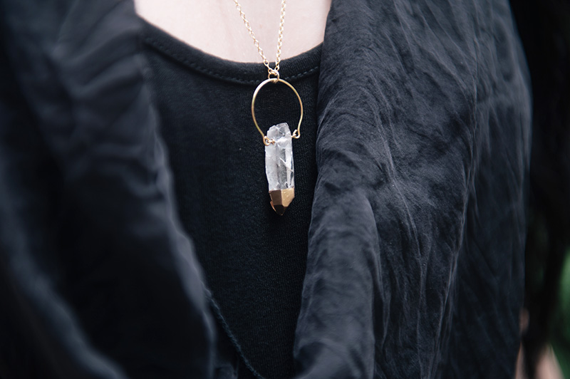 YoungHearts designs gold dipped clear quartz crystal pendant necklace against silk top