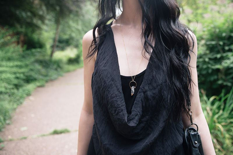 YoungHearts designs gold dipped clear quartz crystal pendant necklace against draped black silk top