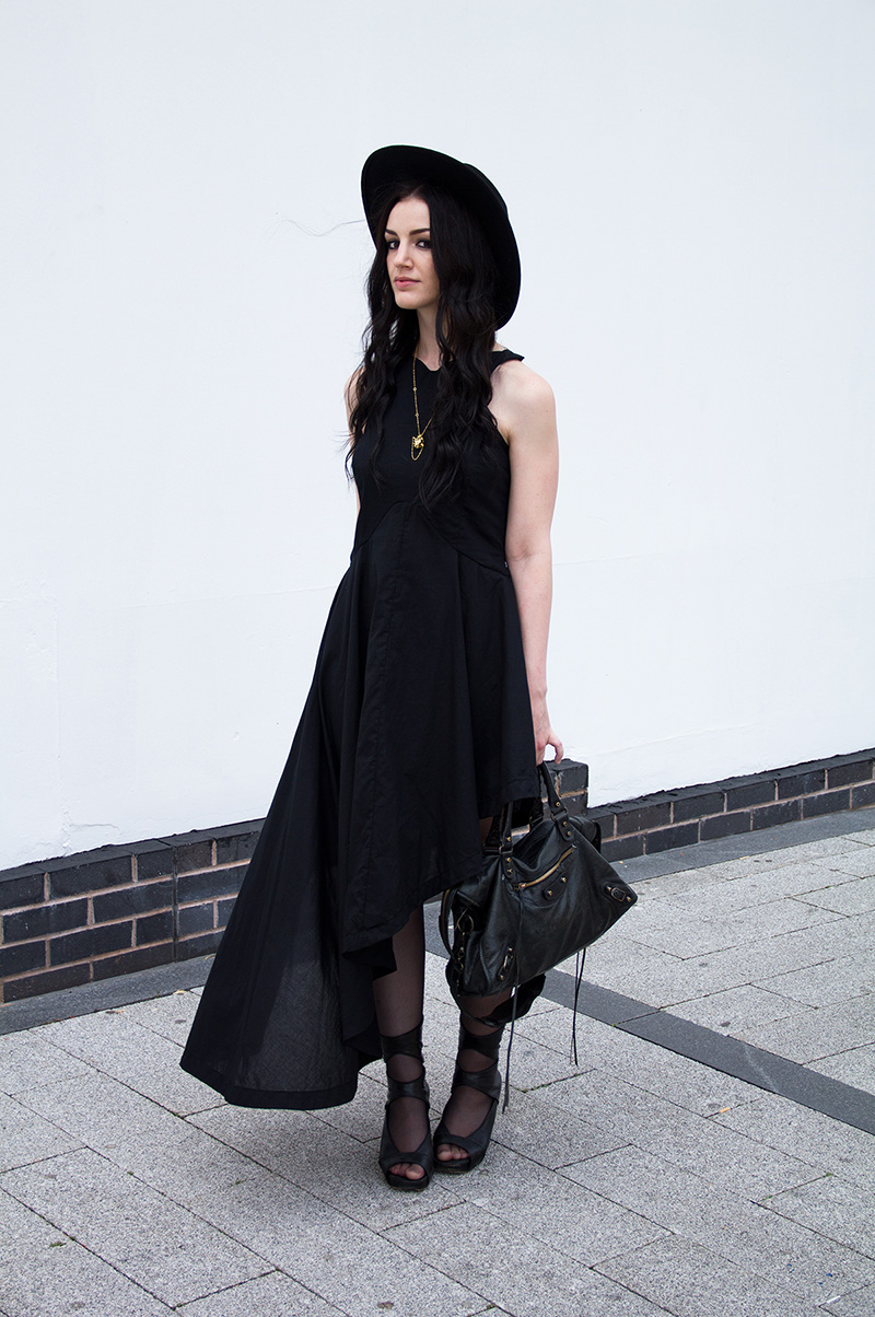 Fashion Blogger Stephanie of FAIIINT shot by Rosemary Pitts of Creatures Blog wearing FAIIINT asymmetric dress, Kasun London vampire heart necklace, Rick Owens wedges, Catarzi large fedora, Balenciaga city bag. All black, gothic street style outfit.