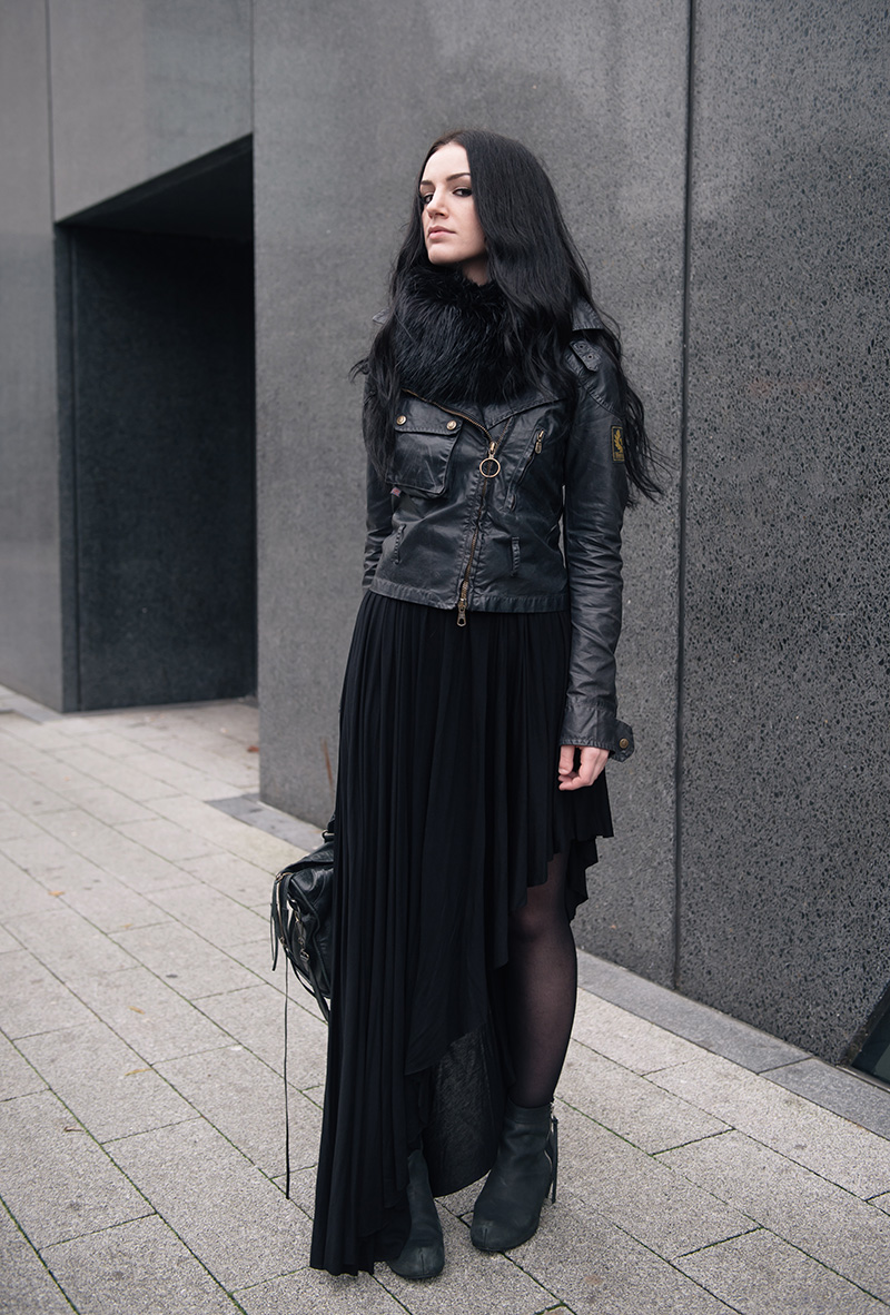 Fashion blogger Stephanie of FAIIINT wearing FAIIINT faux fur snood, Belstaff Sammy Miller waxed jacket, H&M asymmetric jersey maxi skirt, Kurt Geiger wedge boots, Balenciaga city bag. All black street style outfit.