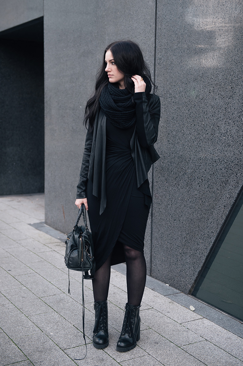 Fashion blogger Stephanie of FAIIINT wearing ASOS Knitted snood, Barneys Originals draped leather jacket, H&M knot twist dress, Giles Deacon Libertine thorn gold ring, Ash Poker lace up boots, Balenciaga city bag. All black everything street style outfit.