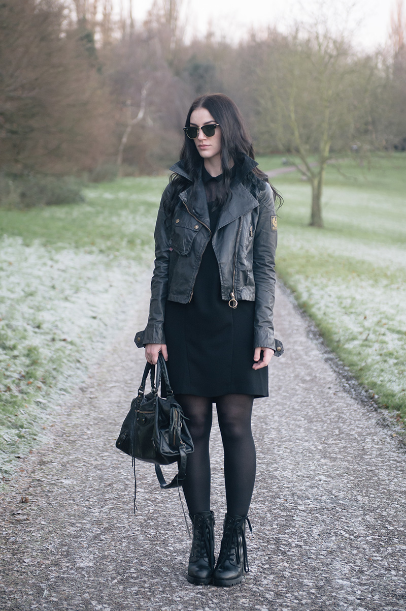 Fashion blogger Stephanie of FAIIINT wearing Ray Ban Clubmaster, Belstaff waxed sammy miller biker jacket, The Kooples shirt dress, Ash Poker Boots, Balenciaga City bag. All black casual outfit.