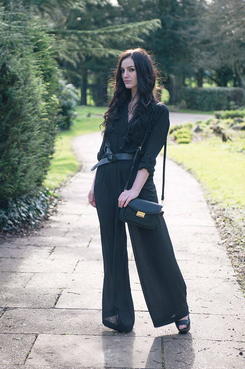 Fashion blogger Stephanie of FAIIINT wearing F&F utility black chiffon jumpsuit, H&M knotted belt, Marc B Jude satchel bag, Sara Gunn bone necklace, Skin by Finsk wedges. All black casual 70s goth street style outfit.