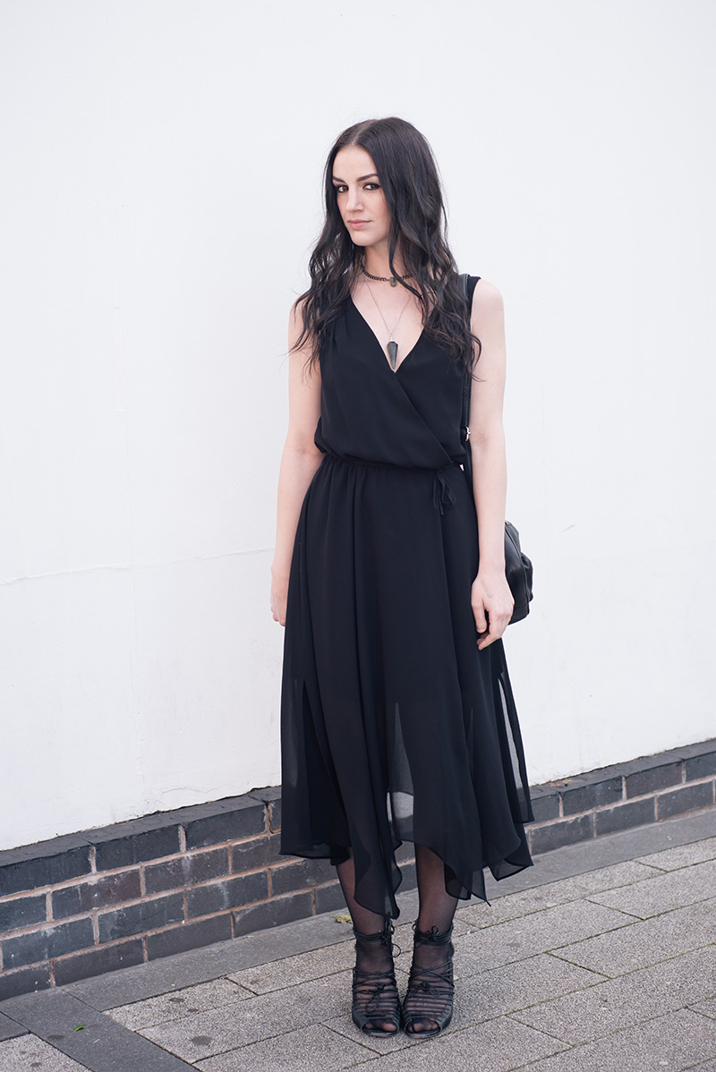 Fashion blogger Stephanie of FAIIINT wearing Warehouse chiffon wrap dress, Regal Rose Rua gemstone point choker, Regal Rose Cosmos Labradorite crystal pendulum necklace, Betty Jackson Black bag, Skin by Finsk lace up wedges. All black gothic witch street style summer outfit.