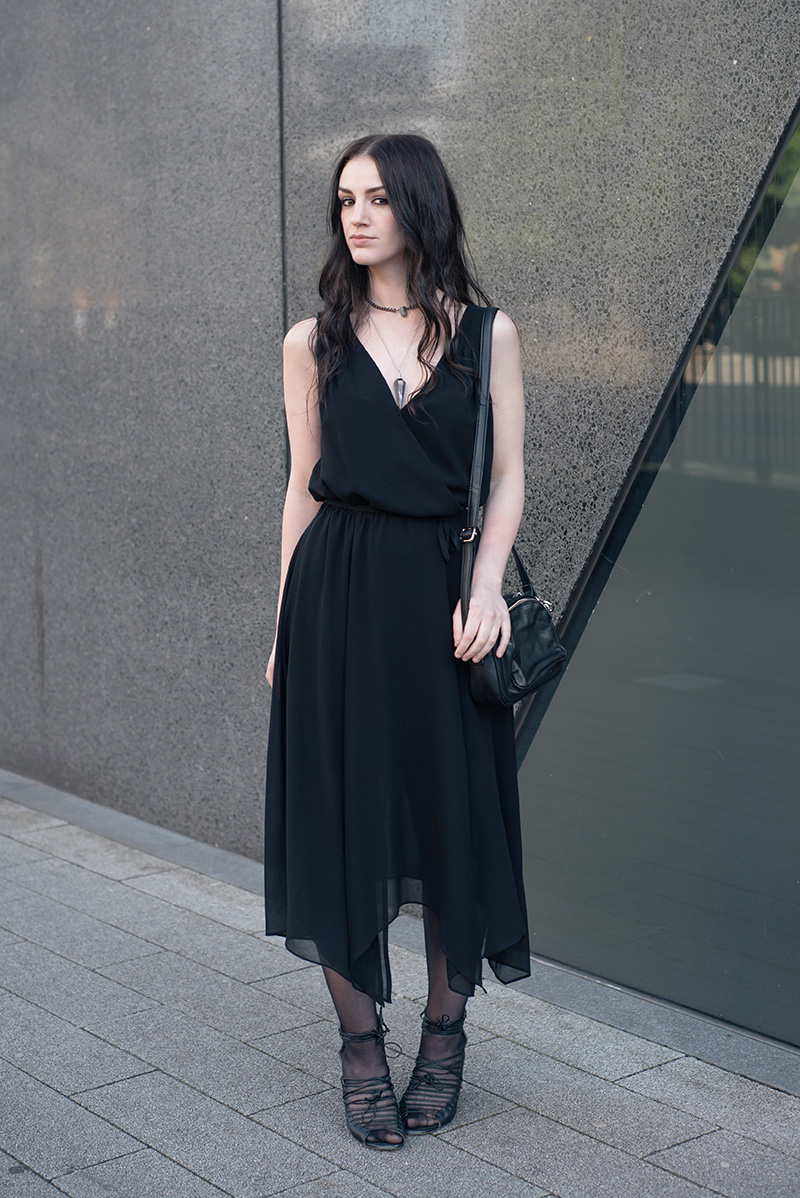 Fashion blogger Stephanie of FAIIINT wearing Warehouse chiffon wrap dress, Regal Rose Rua gemstone point choker, Regal Rose Cosmos Labradorite crystal pendulum necklace, Betty Jackson Black bag, Skin by Finsk lace up wedges. All black gothic witch street style summer outfit.