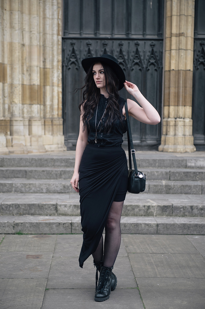 Fashion blogger Stephanie of FAIIINT wearing Catarzi wide brim fedora, Allsaints shirt, FAIIINT draped jersey asymmetric skirt, Ash Poker lace up boots, Hvnter Gvtherer Lacustrine necklace & rings. All black everything dark style goth outfit.