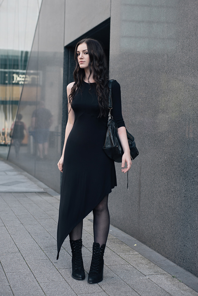 Fashion blogger Stephanie of FAIIINT wearing FAIIINT asymmetric slash one sleeve jersey dress, Kurt Geiger lace up Saturn suede boots, Balenciaga City bag, A Weathered Penny brass rings. All black everything street style summer goth outfit.