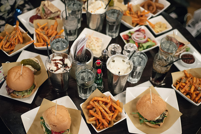 FAIIINT Handmade Burger Co at Highcross Leicester. View from above of table of burgers, sweet potato fries and shakes.