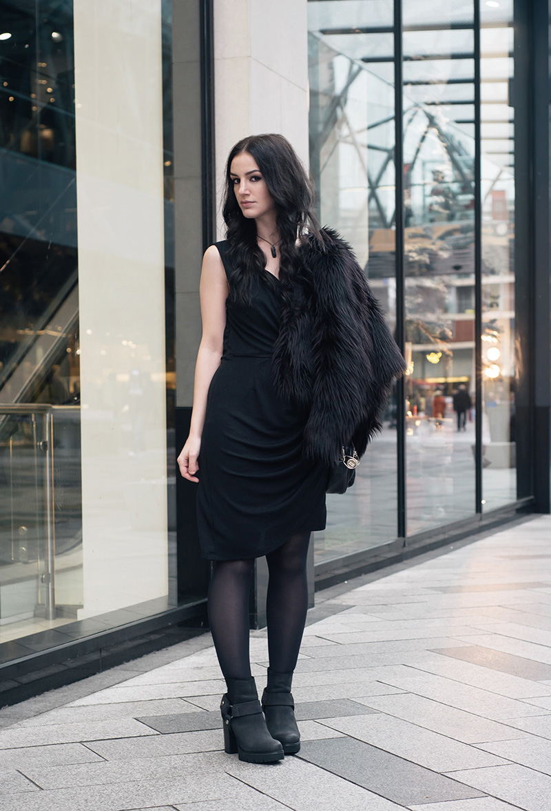 Fashion blogger Stephanie of FAIIINT wearing H&M faux fur cropped jacket, Selected Femme draped glitter dress, New Look stirrup ankle boots, Elemental Luxury necklace, Betty Jackson Black bag. All black everything dark street style outfit.