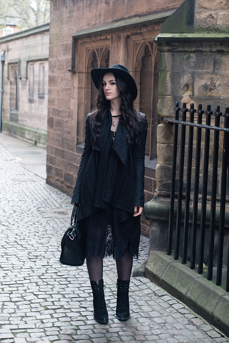 Fashion blogger Stephanie of FAIIINT wearing Catarzi fedora, Todd Lynn x Topshop cropped jacket, H&M draped waterfall cardigan, SheIn lace dress, Kurt Geiger saturn lace up boots. All black everything dark street style outfit.