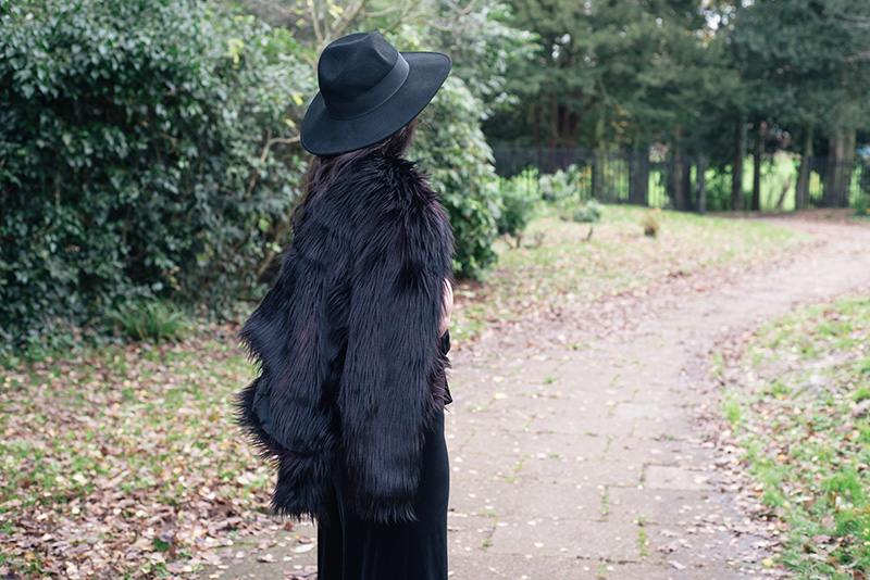 Fashion blogger Stephanie of FAIIINT wearing Catarzi fedora, H&M Faux fur jacket, F&F chiffon and velvet jumpsuit. All black everything dark style 70s outfit.