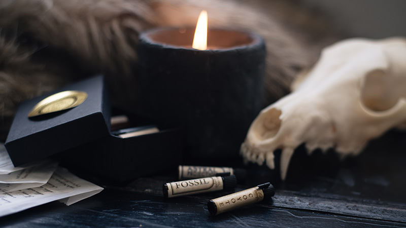 FAIIINT x For Strange Women natural botanical perfume oil sample vials coyote, fossil and astral projection in still life with coyote skull, faux fur and candle.