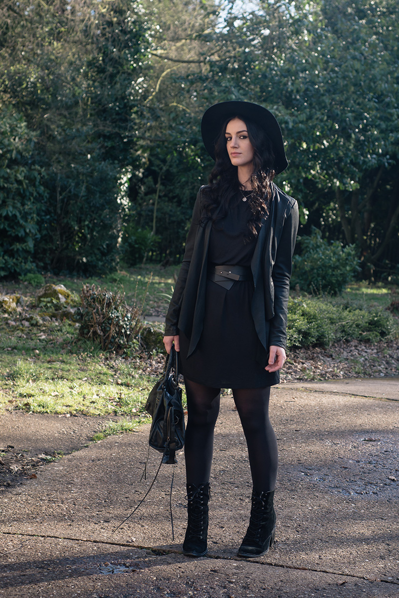Fashion blogger Stephanie of FAIIINT wearing Warehouse wide brim hat, Barney's Originals draped leather jacket, Vero Moda tee dress, Pieces leather wrap belt, Kurt Geiger Saturn lace up boots, Balenciaga city bag. All black everything casual dark street style outfit.