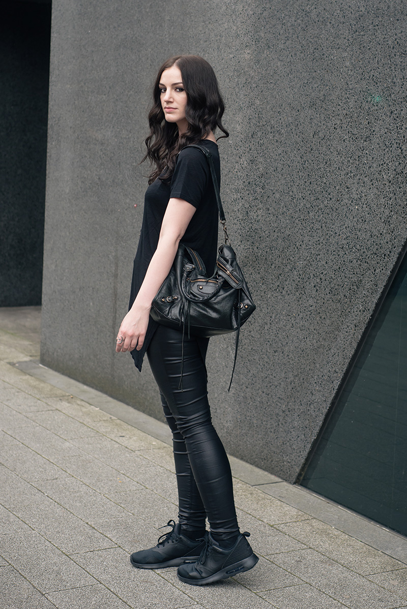 Fashion blogger Stephanie of FAIIINT wearing H&M asymmetric tee shirt, New Look coated jeans, Nike triple black Air Max Tavas trainers, Hvnter Gatherer Lacustrine necklace, Balenciaga city bag. All black everything casual goth dark street style outfit..