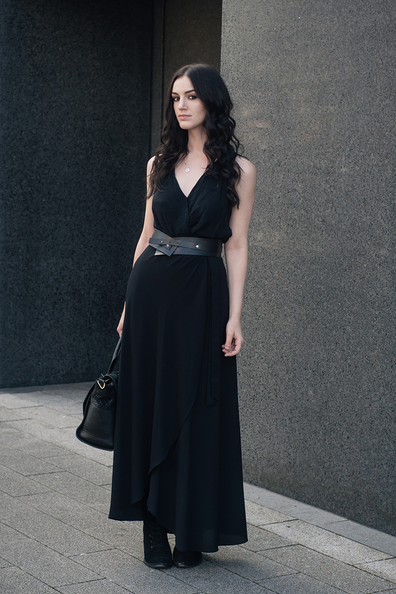 Fashion blogger Stephanie of FAIIINT wearing River Island draped top, New Look wrap maxi skirt, Pieces leather belt, Ailsigr jewellery, Kurt Geiger Saturn boots. All black everything summer street style outfit.