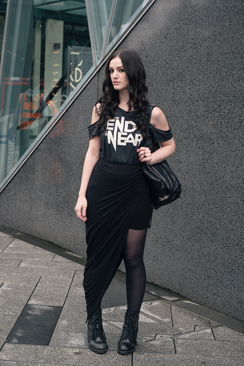 Fashion blogger Stephanie of FAIIINT wearing H&M The End Is Near tee, draped asymmetric skirt, ASH poker boots, Topshop backpack. All black everything street style outfit.