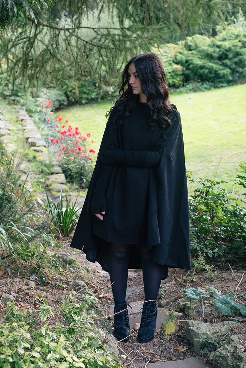 Fashion blogger Stephanie of FAIIINT wearing Necessary Evil Morrigan wool cape, Black.co.uk cashmere wrist warmers, The Rogue + The Wolf Occult ring, Kurt Geiger Solar ponyhair wedge lace up boots. All black gothic autumn outfit.