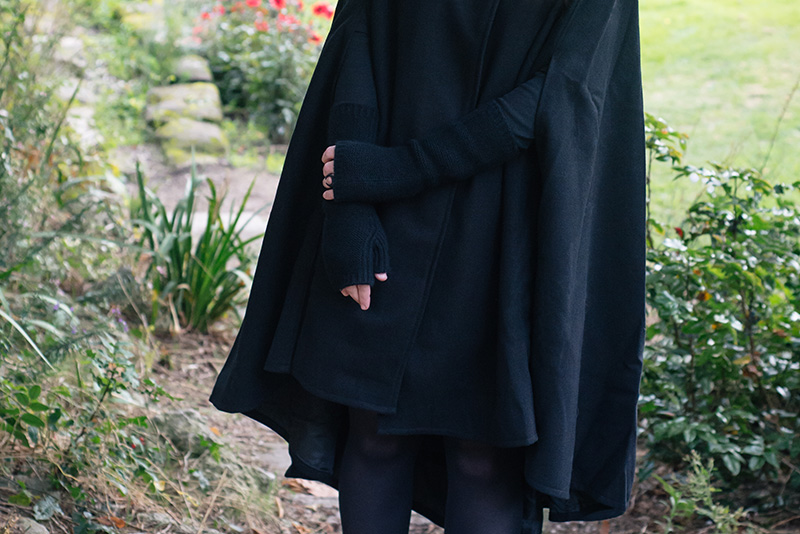 Fashion blogger Stephanie of FAIIINT wearing Necessary Evil Morrigan wool cape, Black.co.uk cashmere wrist warmers, The Rogue + The Wolf Occult ring. All black gothic autumn outfit details.