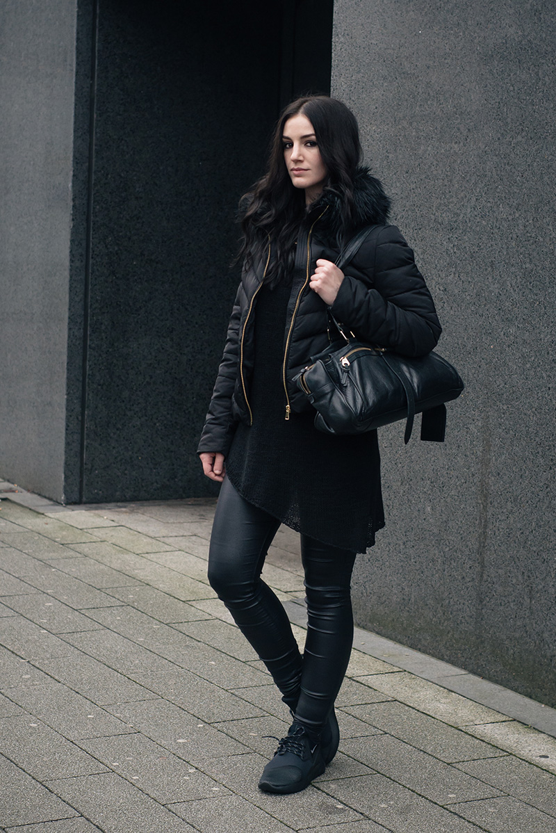 Fashion blogger Stephanie of FAIIINT wearing H&M quilted padded down jacket with faux fur collar, H&M asymmetric jumper, New Look coated skinny jeans, Nike black LunarCharge trainers, Mulberry Mabel bag. All black winter street style outfit.