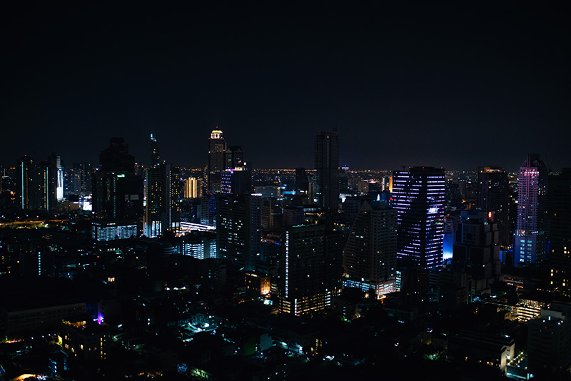 Bangkok Thailand city skyline with skyscrapers at night from the top of Zoom rooftop sky bar.