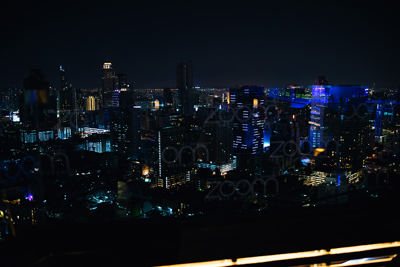 Bangkok Thailand city skyline with skyscrapers at night from the top of Zoom rooftop sky bar.