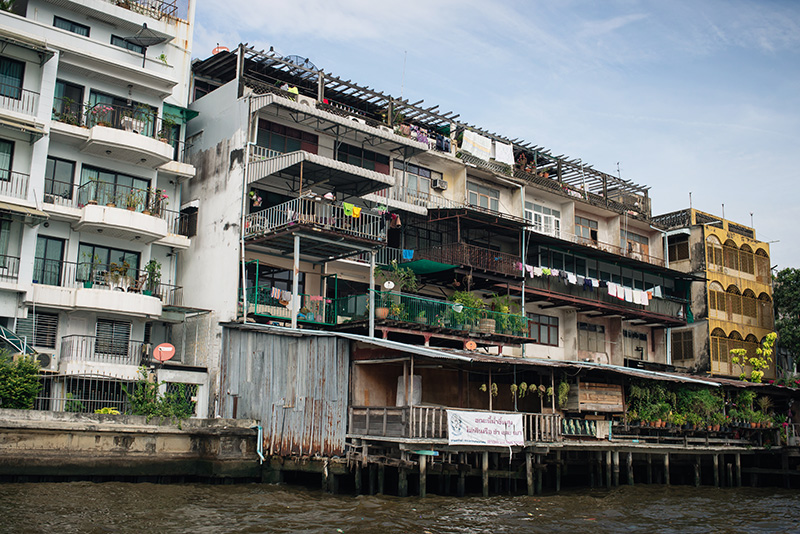 Bangkok Thailand Chao Phraya River riverfront apartments and balconies with colourful washing hanging up.