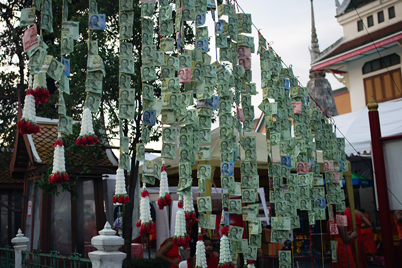Temples of Bangkok Thailand, Wat Arun the Temple of Dawn, money offerings hanging across pathway.