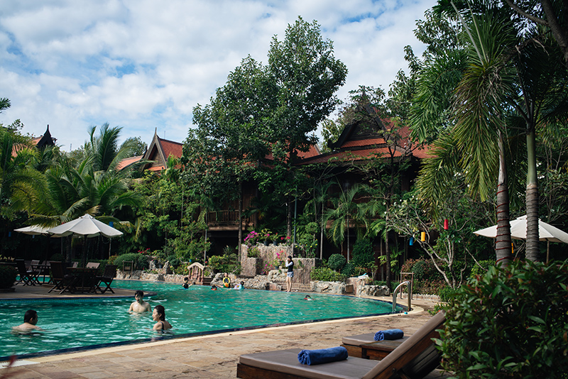 Sokhalay Angkor Villa Resort in Siem Reap Cambodia, pool area with palm trees and flowers.