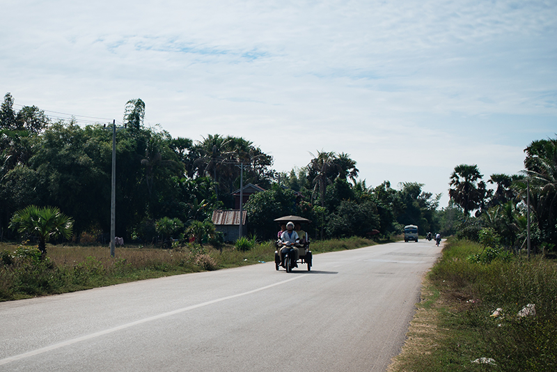 Motorbiking through the Siem Reap countryside in Cambodia, tuk tuks on the road.