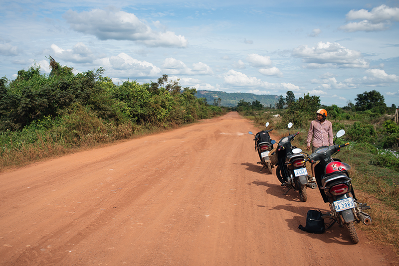 Motorbiking throught the Siem Reap countryside in Cambodia on a Honda Dream with Khmer Ways. Dusty red orange sand roads.