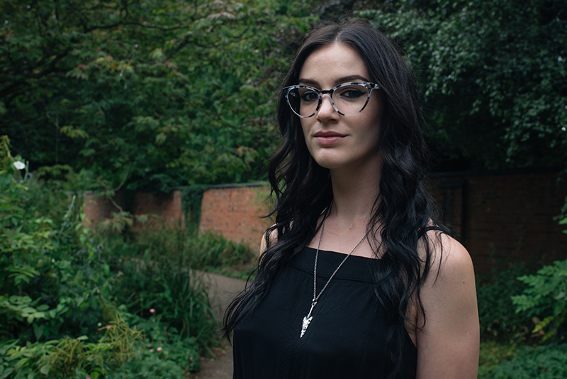 Fashion blogger Stephanie of FAIIINT wearing IOLLA Muir smoke tortoise cat eye frames glasses, Toilworn arrowhead pendent necklace. Portrait, outfit details.