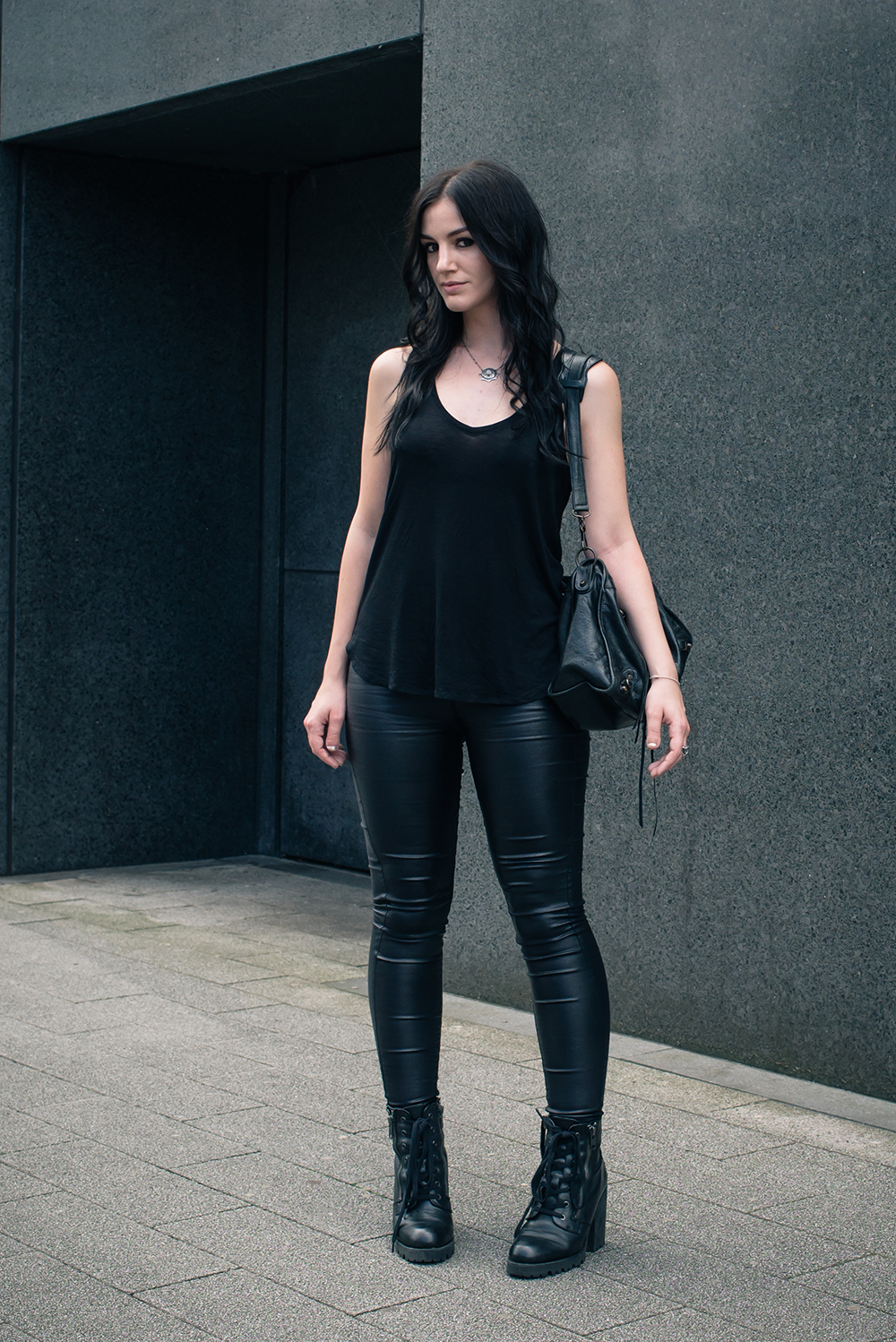 Fashion blogger Stephanie of FAIIINT wearing H&M black coated skinny jeans and tank top, ASH poker lace up ankle boots, Balenciaga city bag. All black simple dark street style outfit.