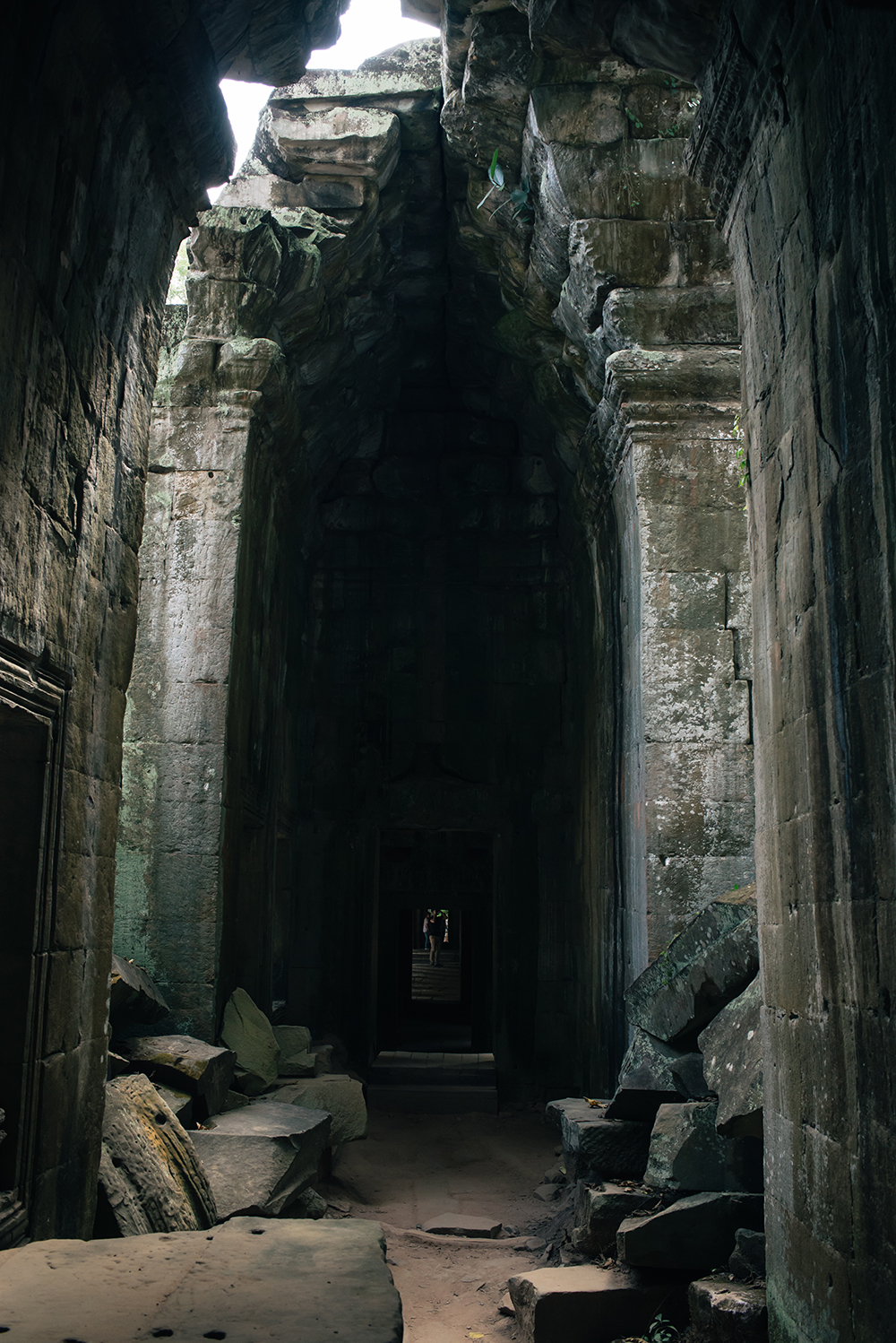 Ta Prohm temple arch hallway Siem Reap Angkor Cambodia. Crumbling ruins reclaimed by nature and overgrown with trees and plants.