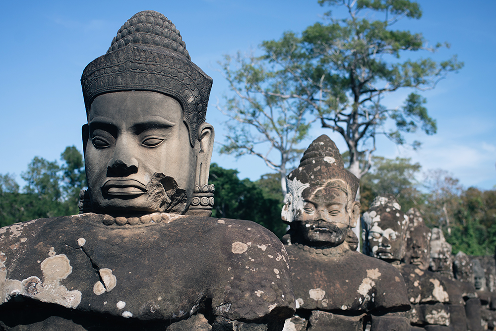 Bayon temple ruins Siem Reap Angkor Cambodia, Buddha faces and heads along the bridge.
