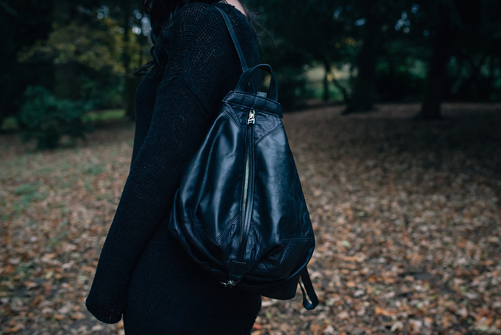 Fashion blogger Stephanie of FAIIINT wearing H&M black asymmetric knit jumper, Topshop backpack. All black autumn outfit details..