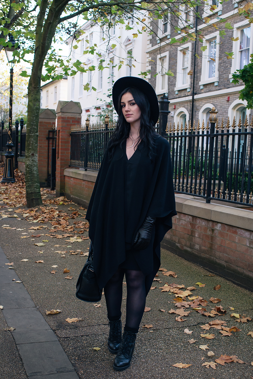 Fashion blogger Stephanie of FAIIINT wearing ASOS cape, H&M wide brim fedora, Black elbow high leather gloves, ASH poker lace up boots. Gothic style all black autumn outfit.
