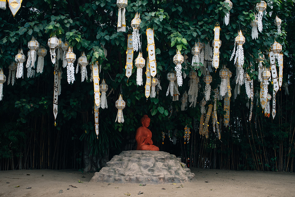Wat Phan Tao flags and Buddha statue garden, Chiang Mai Thailand.