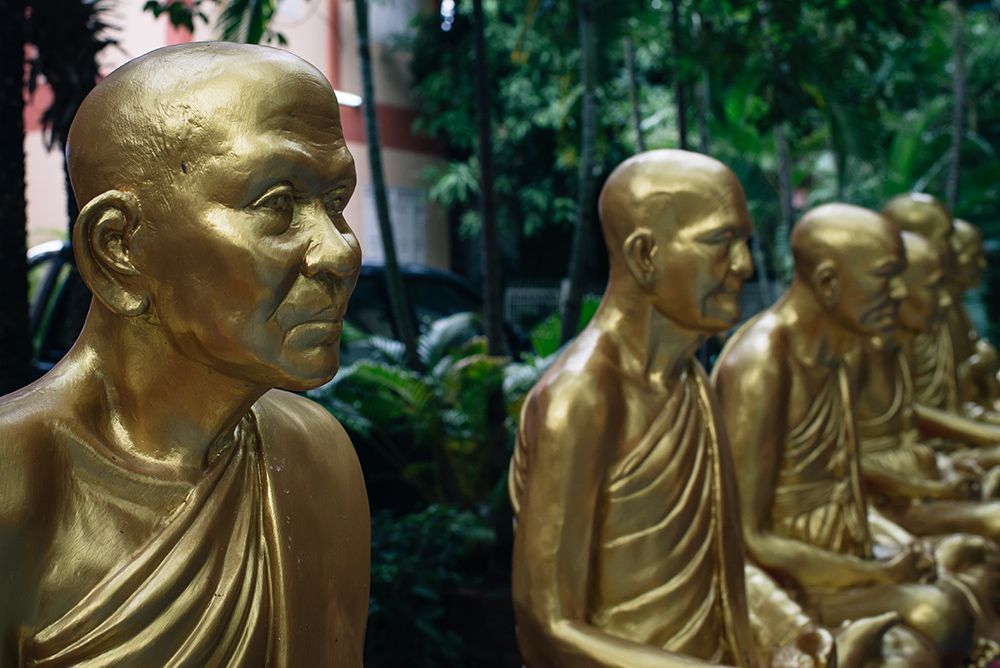 Wat Phra Singh golden monk statues Chiang Mai Thailand.