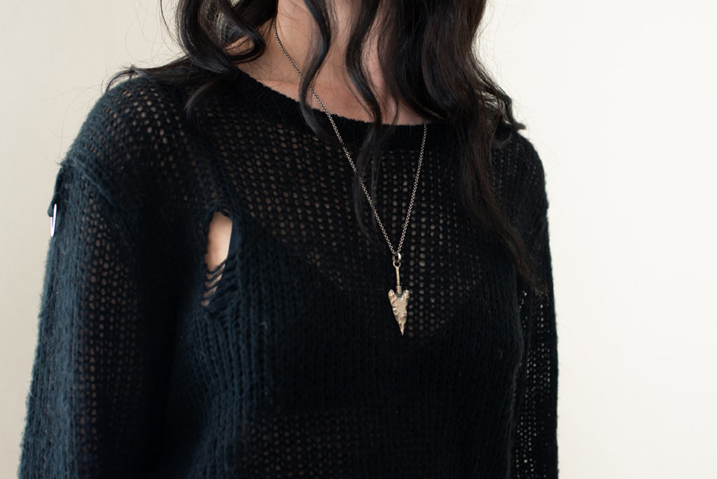 Outfit details featuring Killstar high voltage sweater and Toilworn arrowhead necklace.