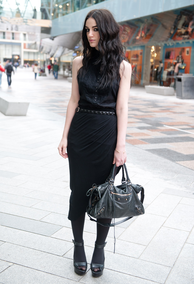 Fashion blogger Stephanie of FAIIINT wearing AllSaints Sleeveless Shirt, River Island Draped Asymmetric Skirt, Skin by Finsk Wedge Sandals, Topshop Studded Belt, ASOS Spiked Bangle, Balenciaga City bag. All black, dark, gothic, street style.