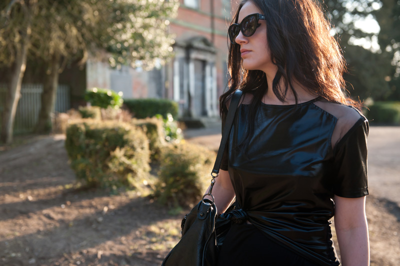 Fashion blogger Stephanie Brown of FAIIINT wearing MeeMee wet look cut out tee, River Island asymmetric skirt, Rick Owens wedges, Balenciaga city, AllSaints cateye sunglasses. Spring Summer gothic street style. All Black.
